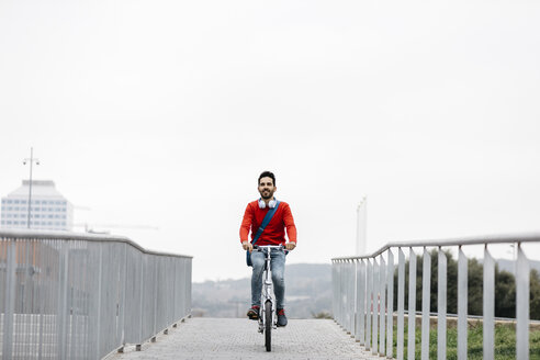 Casual businessman commuting in the city, using his folding bike - JRFF02836