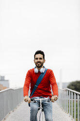 Casual businessman commuting in the city, using his folding bike - JRFF02837