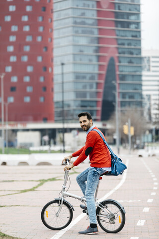 Geschäftsmann, der mit seinem Klapprad in der Stadt pendelt, lizenzfreies Stockfoto