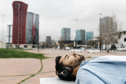 Mann macht eine Pause in der Stadt und hört Musik, lizenzfreies Stockfoto