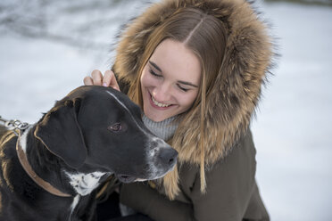 Glückliche junge Frau mit Hund im Winter - LBF02434