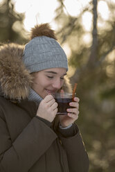 Porträt einer jungen Frau, die eine Tasse Tee im Winter genießt - LBF02436