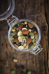 Einmachglas mit gerösteten Sojabohnen, Samen und Nüssen auf Holz - LVF07876