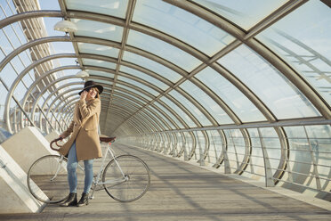 junge Hipster-Frau mit Fahrrad in einem modernen Tunnel - AHSF00042