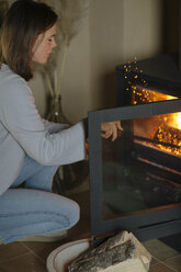 Woman burning wood in fireplace - ALBF00819