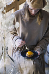 Frau isst Pfirsich-Törtchen mit Gabel - ALBF00834