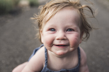 Close-up-Porträt von niedlichen lächelnden Baby Mädchen sitzen auf der Straße im Wald - CAVF63195