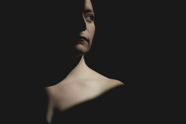 Thoughtful topless woman looking away while standing in darkroom - CAVF63239