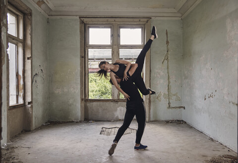 Man lifting ballerina while practicing ballet in old building stock photo