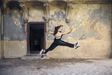 Ballet dancers leaping while dancing together in old building - CAVF63258