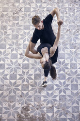 High angle view of ballet dancers dancing together on floor in old building - CAVF63259