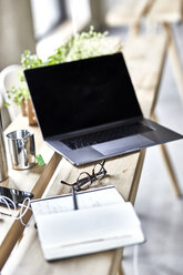 Notebook und Laptop auf Holzbrettern im Büro - FMKF05487