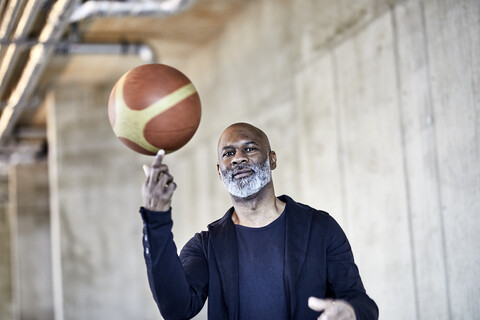 Porträt eines reifen Geschäftsmannes mit Basketball in einem modernen Büro, lizenzfreies Stockfoto