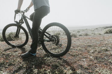 Spanien, Lanzarote, tiefer Ausschnitt eines Mountainbikers auf einem Ausflug in wüstenhafter Landschaft - AHSF00075