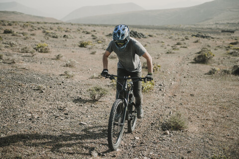 Spanien, Lanzarote, Mountainbiker auf einem Ausflug in wüstenhafter Landschaft, lizenzfreies Stockfoto