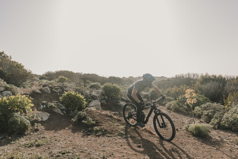 Spanien, Lanzarote, Mountainbiker auf einem Ausflug in wüstenhafter Landschaft, lizenzfreies Stockfoto