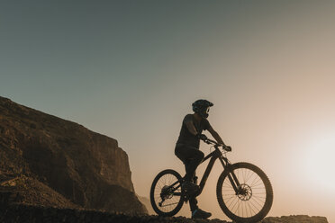 Spanien, Lanzarote, Mountainbiker auf einem Ausflug bei Sonnenuntergang - AHSF00100