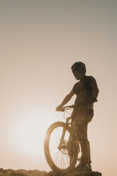 Spanien, Lanzarote, Mountainbiker auf einem Ausflug bei Sonnenuntergang - AHSF00101