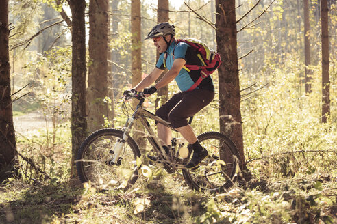 Mann fährt Mountainbike auf Waldweg - SEBF00063