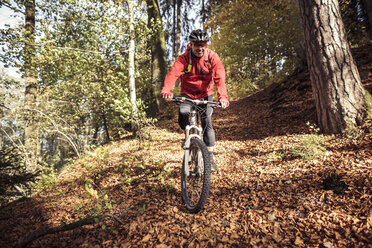 Mann fährt Mountainbike auf Waldweg - SEBF00065