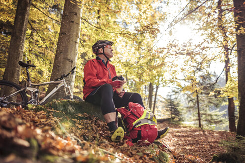 Mann mit Mountainbike macht eine Pause im Wald - SEBF00066