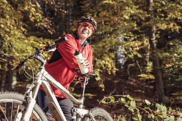 Mann mit Mountainbike macht eine Pause im Wald - SEBF00071