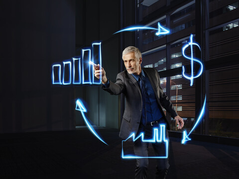 Geschäftsmann malt Wirtschaftskreislauf mit Licht, lizenzfreies Stockfoto