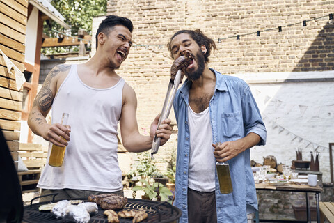Friends preparing meat for a barbecue in the backyard stock photo