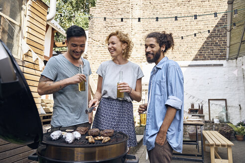 Freunde beim Grillen im Garten, die Fleisch auf dem Grill zubereiten - PDF01817