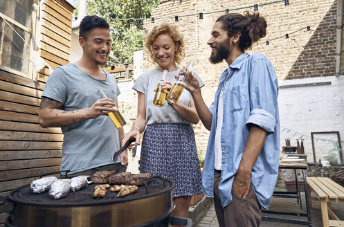 Freunde beim Grillen im Garten, die Fleisch auf dem Grill zubereiten - PDF01818