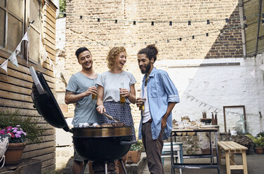 Freunde beim Grillen im Garten, die Fleisch auf dem Grill zubereiten - PDF01823