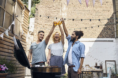 Friends having a barbecue n the backyard, preparing meat on a grill - PDF01824