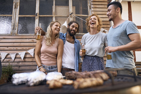 Freunde haben Spaß bei einer Grillparty und trinken Bier, lizenzfreies Stockfoto