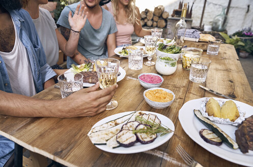 Freunde haben Spaß bei einer Grillparty und essen gemeinsam - PDF01844