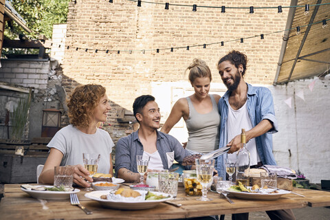 Friends having fun at a barbecue party, eating together stock photo