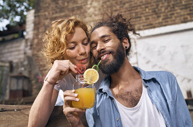 Junges Paar trinkt kühle Limonade in einem Hinterhof - PDF01865