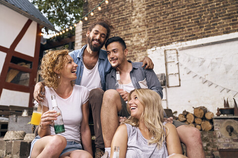 Freunde, die sich im Sommer in einem Hinterhof amüsieren, lizenzfreies Stockfoto