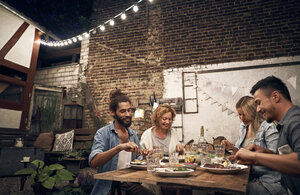 Freunde grillen im Hinterhof und essen gemeinsam - PDF01883
