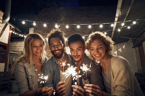Freunde feiern eine Party im Garten, brennen Wunderkerzen ab - PDF01884