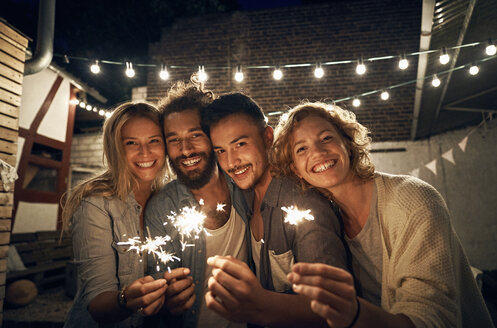 Freunde feiern eine Party im Garten, brennen Wunderkerzen ab - PDF01885