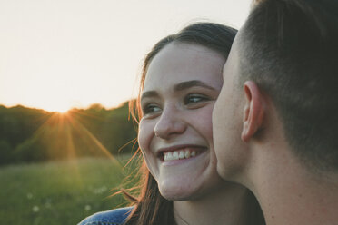 Porträt eines verliebten Teenagers, der von seinem Freund bei Sonnenuntergang geküsst wird - ANHF00091