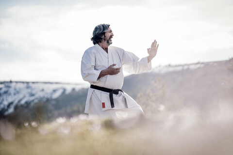 Älterer Mann übt Karate im Freien, lizenzfreies Stockfoto