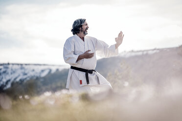 Älterer Mann übt Karate im Freien - OCMF00304