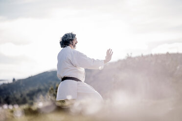 Älterer Mann übt Karate im Freien - OCMF00305