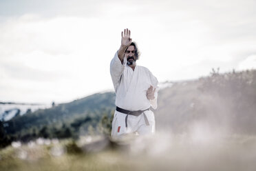 Älterer Mann übt Karate im Freien - OCMF00306