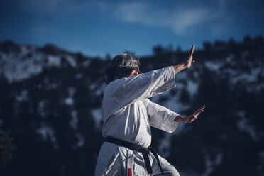 Senior man practicing karate outdoors - OCMF00310