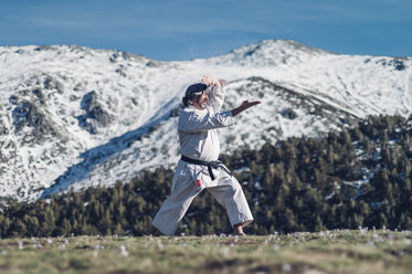 Älterer Mann übt Karate im Freien - OCMF00312