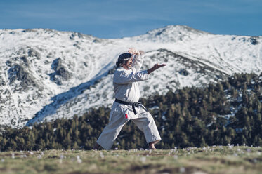Senior man practicing karate outdoors - OCMF00312
