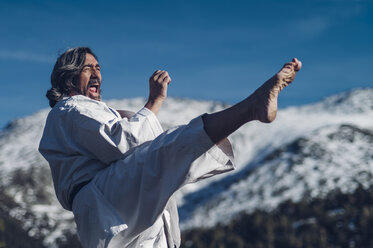 Älterer Mann übt Karate im Freien - OCMF00313