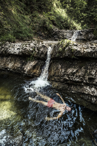 Germany, Upper Bavaria, Bavarian Prealps, lake Walchen, young man is swimming in a plunge pool stock photo